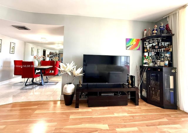 living room featuring bar and hardwood / wood-style flooring