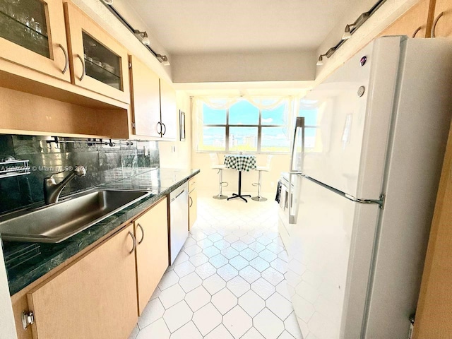 kitchen featuring sink, dishwasher, decorative backsplash, light tile patterned floors, and white refrigerator