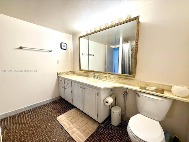 bathroom featuring vanity, toilet, and tile patterned flooring