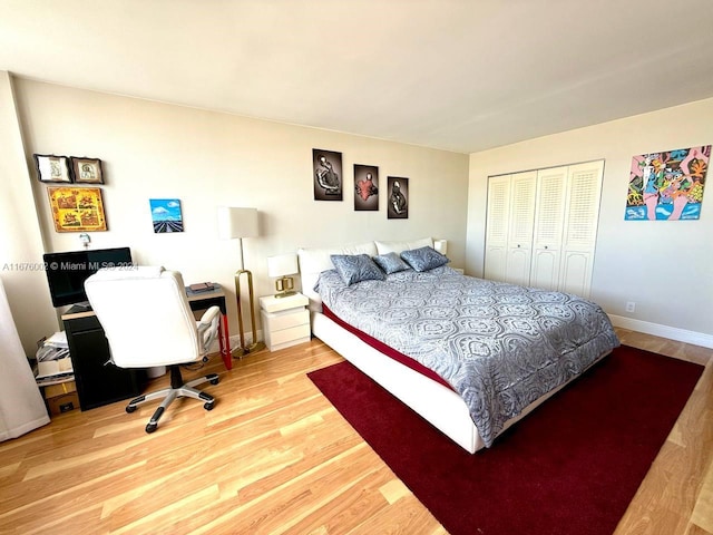 bedroom with light hardwood / wood-style floors and a closet