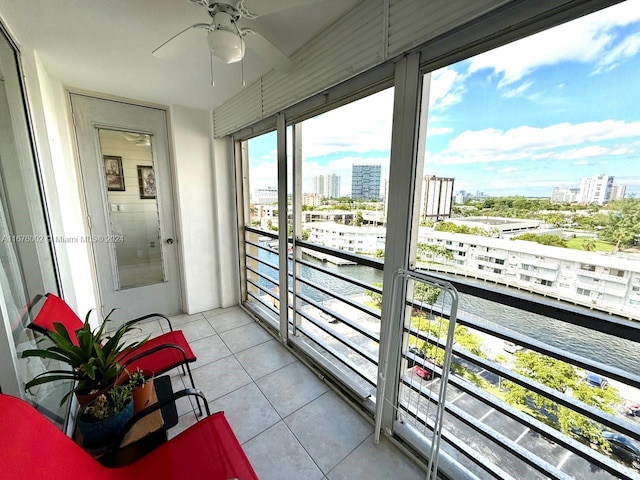 balcony with a water view and ceiling fan