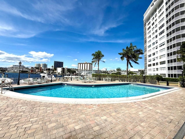 view of pool with a water view and a patio