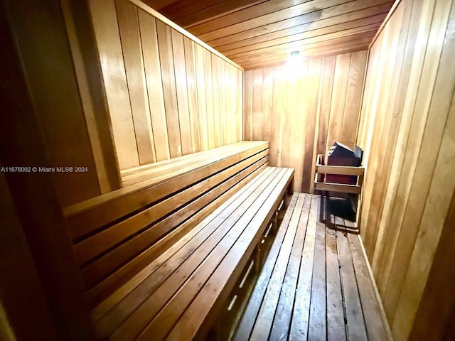 view of sauna / steam room with wood ceiling, hardwood / wood-style flooring, and wooden walls