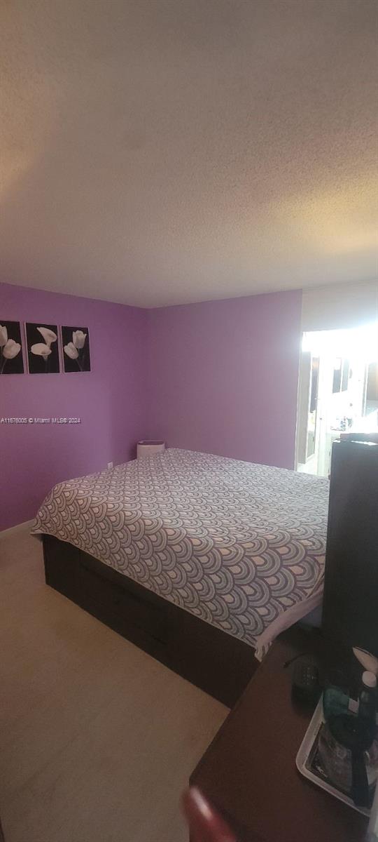 unfurnished bedroom with a textured ceiling and carpet