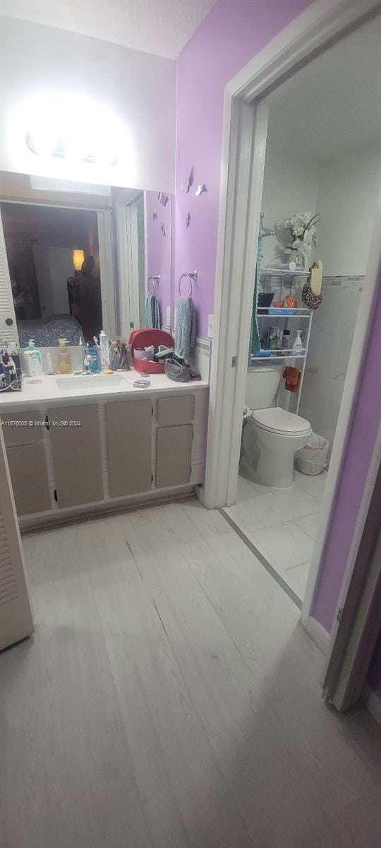 bathroom featuring vanity, hardwood / wood-style floors, and toilet