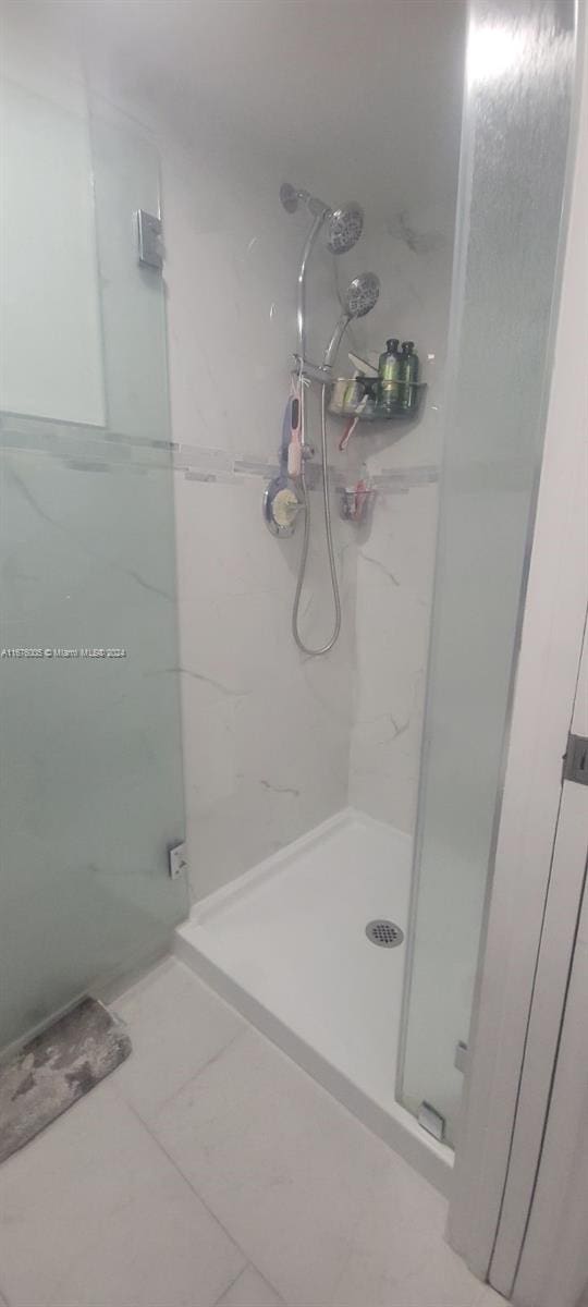 bathroom featuring tile patterned flooring and tiled shower