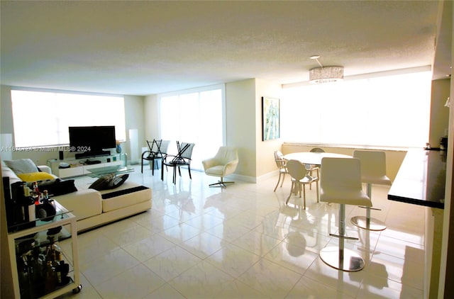 living room featuring light tile patterned floors and a textured ceiling