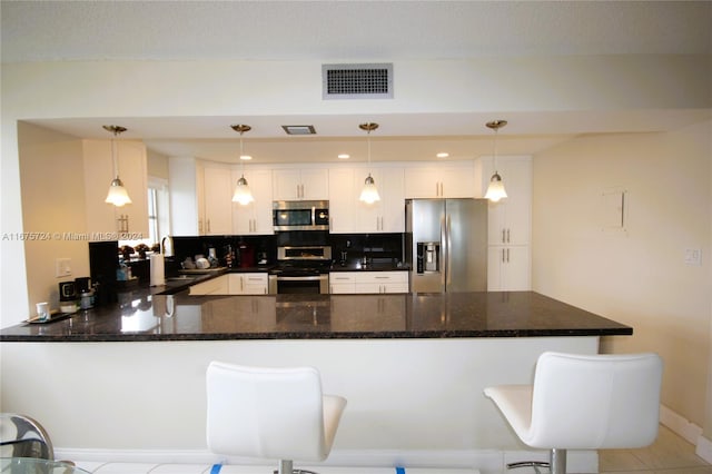 kitchen featuring kitchen peninsula, hanging light fixtures, and stainless steel appliances