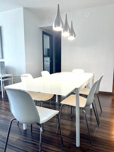 dining space with dark wood-type flooring