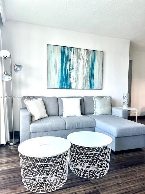 living room with hardwood / wood-style flooring and a textured ceiling