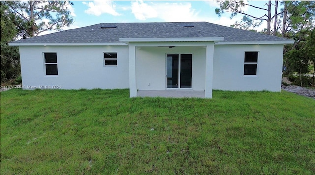 rear view of property featuring a lawn