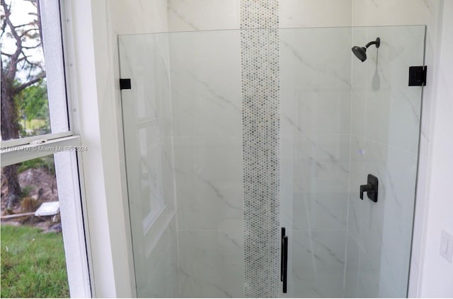 bathroom with a shower with shower door