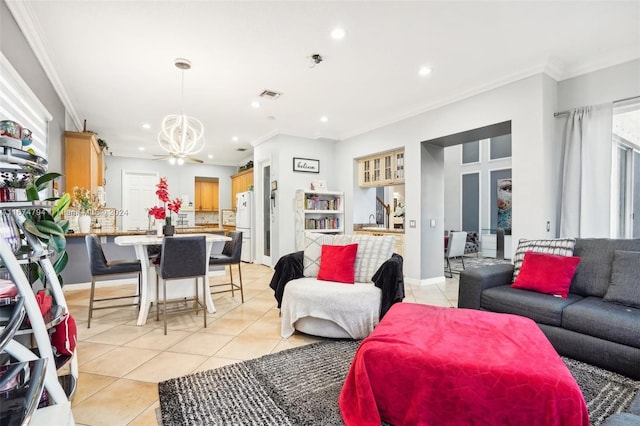 living room with ornamental molding, a notable chandelier, and light tile patterned floors