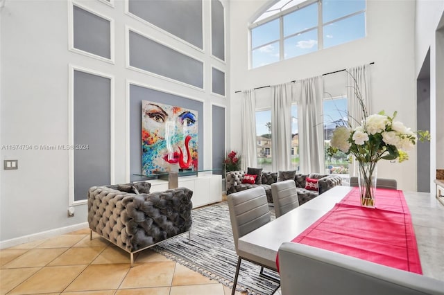 tiled living room featuring a high ceiling and a wealth of natural light