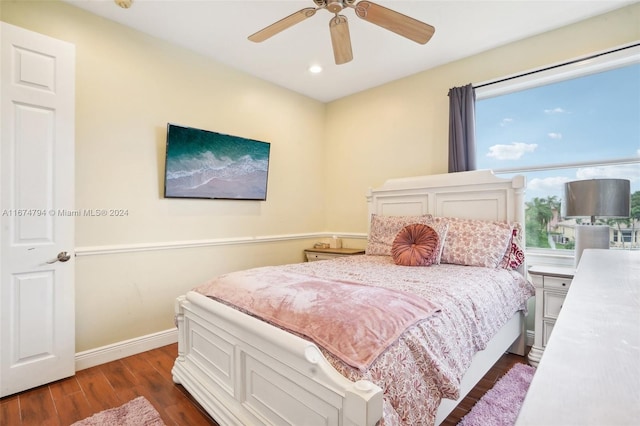 bedroom with ceiling fan, multiple windows, and dark hardwood / wood-style floors