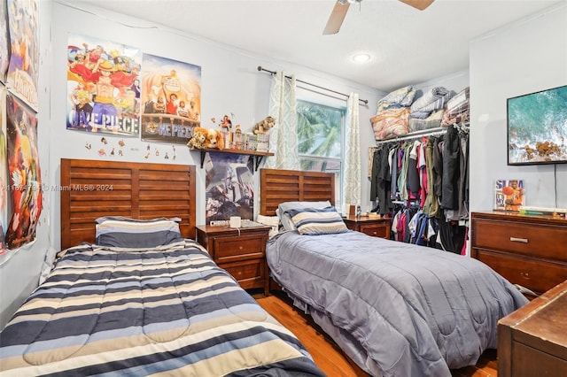 bedroom featuring hardwood / wood-style flooring, ceiling fan, and a closet