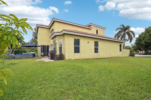 back of house featuring a yard and a patio area