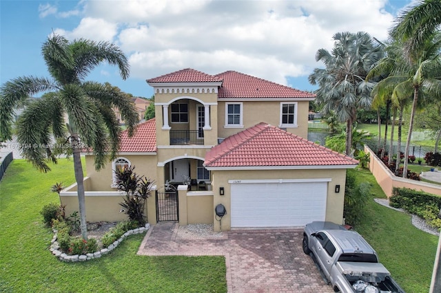 mediterranean / spanish-style house featuring a garage, a front yard, and a balcony