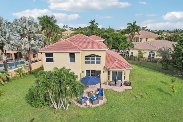 rear view of house with a patio area, a yard, and a pool