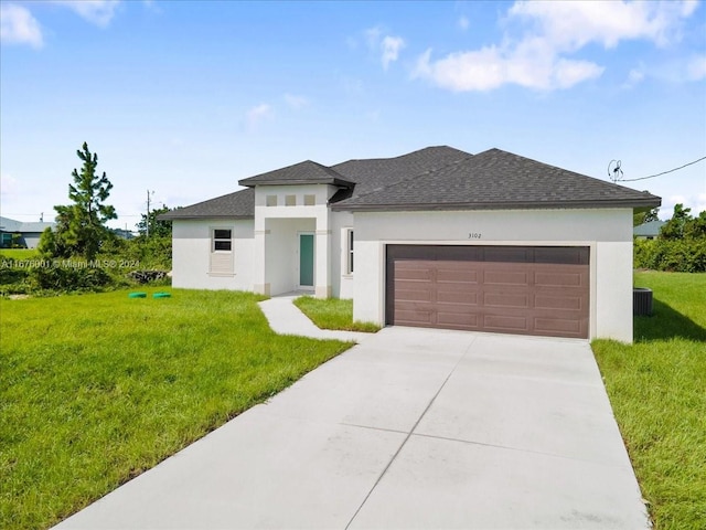 prairie-style house featuring a front lawn, cooling unit, and a garage