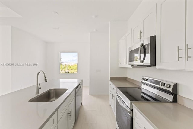 kitchen with white cabinets, appliances with stainless steel finishes, and sink