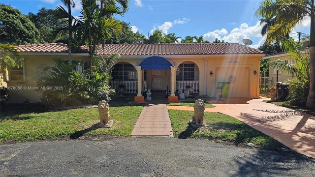 mediterranean / spanish-style house featuring a front lawn and a garage