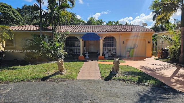 mediterranean / spanish-style house with a garage and a front yard