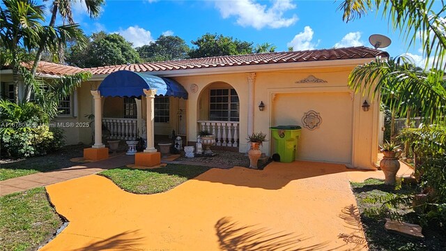 mediterranean / spanish home featuring a front lawn and a garage