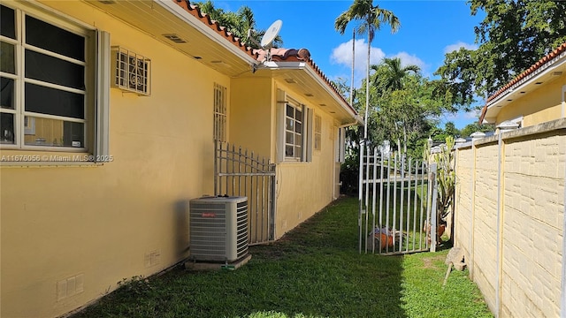 view of home's exterior featuring central AC unit and a lawn