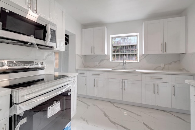 kitchen with white cabinetry, appliances with stainless steel finishes, sink, and tasteful backsplash