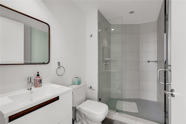 bathroom featuring vanity, an enclosed shower, and toilet