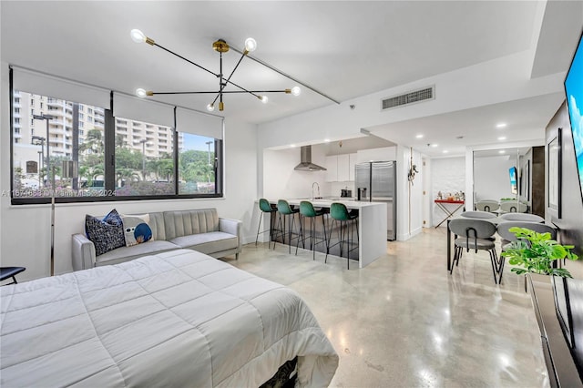 bedroom with stainless steel fridge, sink, and an inviting chandelier