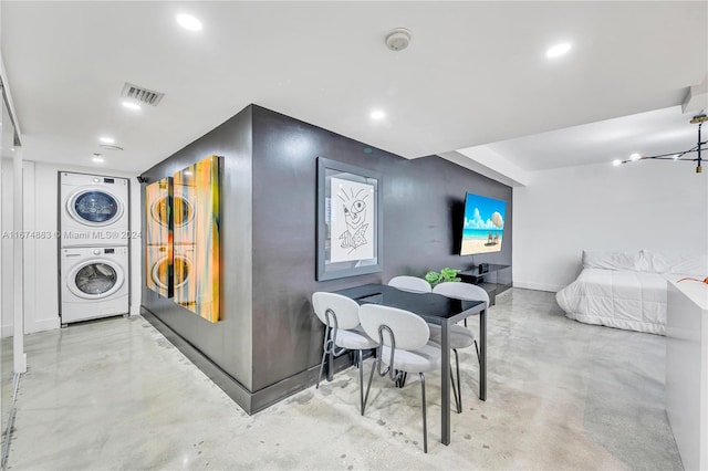 dining space featuring a chandelier and stacked washing maching and dryer