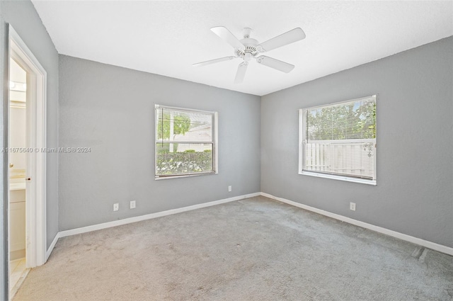 carpeted spare room with ceiling fan