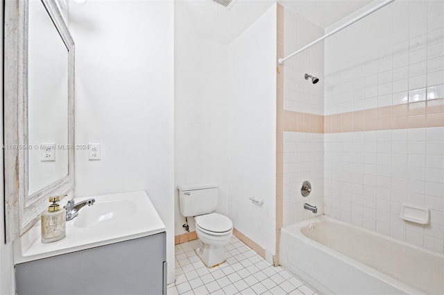 full bathroom with toilet, tiled shower / bath, vanity, and tile patterned flooring