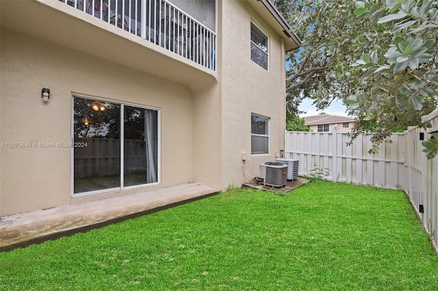 view of yard with a balcony and central air condition unit