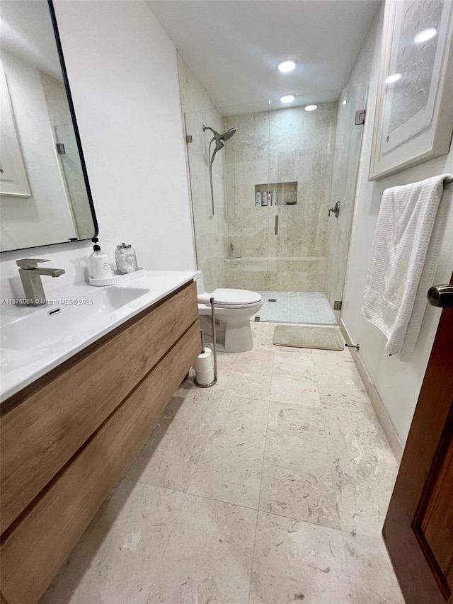 bathroom with toilet, vanity, and an enclosed shower