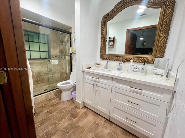 bathroom featuring toilet, an enclosed shower, and vanity