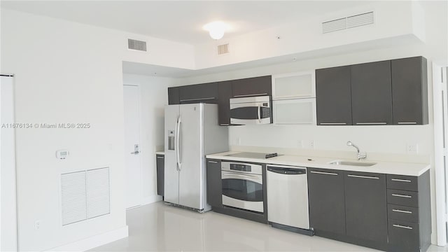 kitchen with visible vents, appliances with stainless steel finishes, light countertops, and a sink