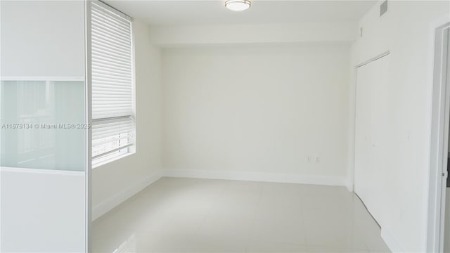 spare room with baseboards and visible vents