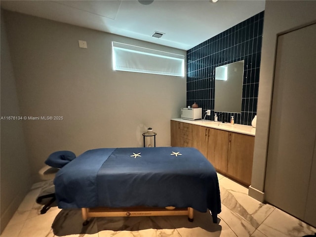 bedroom with marble finish floor, a sink, and visible vents