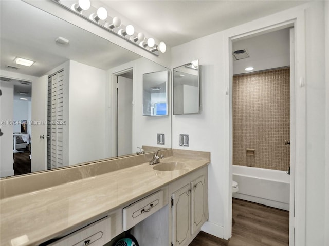 bathroom featuring shower / tub combination, vanity, toilet, and wood finished floors