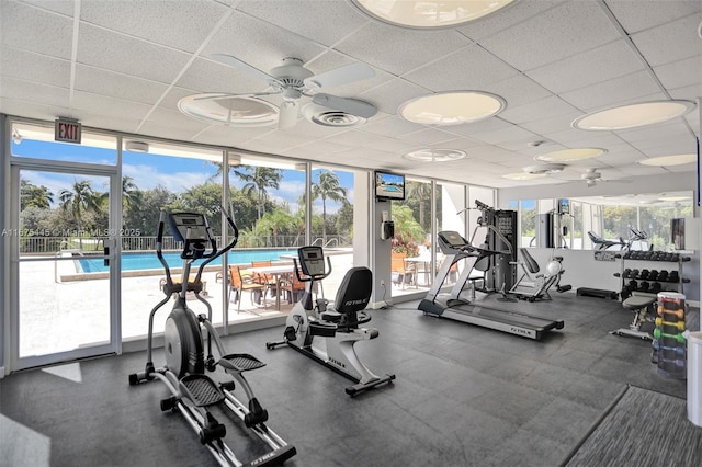 exercise room featuring a wall of windows, a paneled ceiling, visible vents, and plenty of natural light