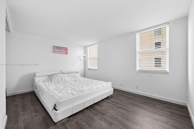 bedroom with dark hardwood / wood-style flooring and multiple windows