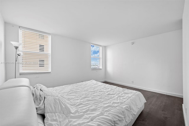 bedroom with dark wood-type flooring