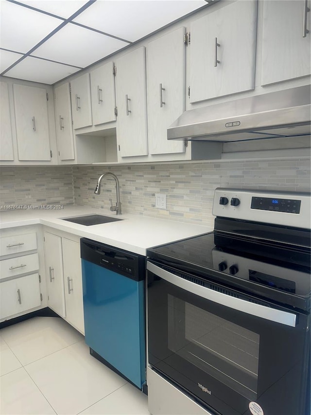 kitchen with sink, light tile patterned floors, backsplash, white cabinets, and appliances with stainless steel finishes