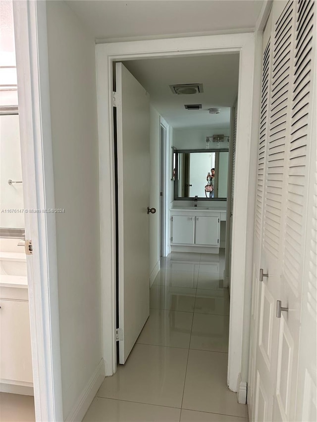 hallway featuring sink and light tile patterned floors