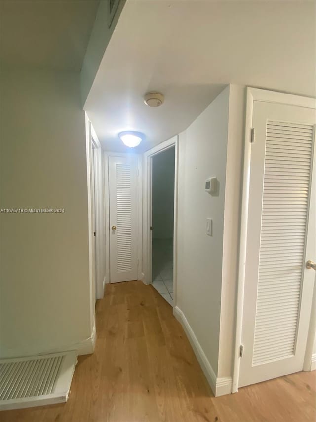 hallway with light hardwood / wood-style floors