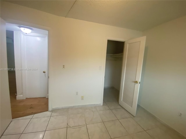 unfurnished bedroom with a closet and light tile patterned floors