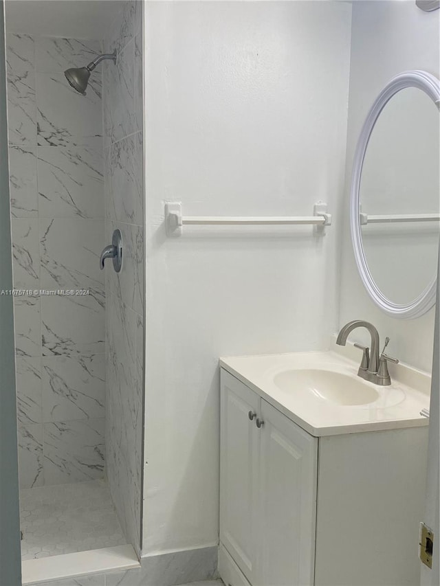 bathroom featuring tiled shower and vanity